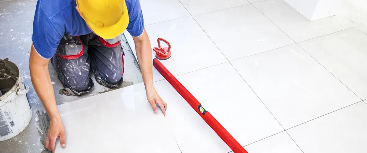 A contractor installing large tile flooring
