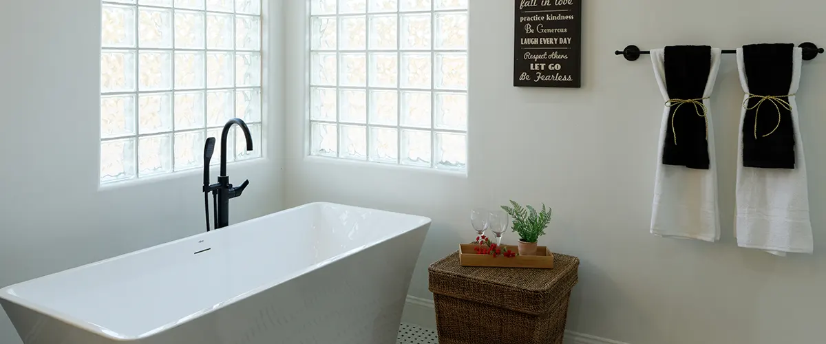 A white tub with two towels and black accents