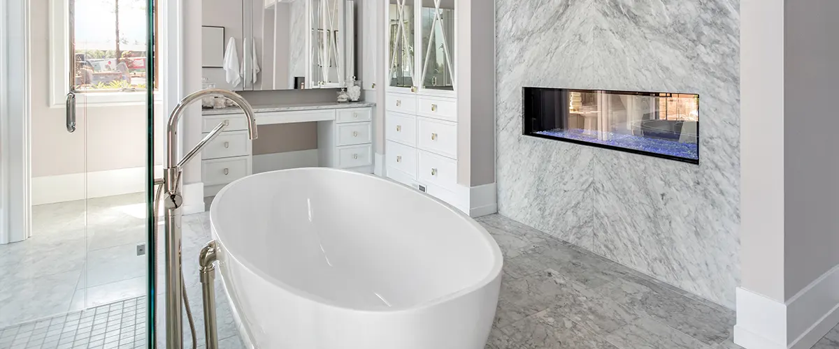 A free standing tub with a fireplace in the wall