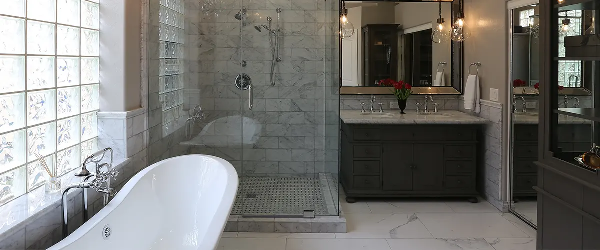 A elegant black bathroom with a white tub and dark vanities