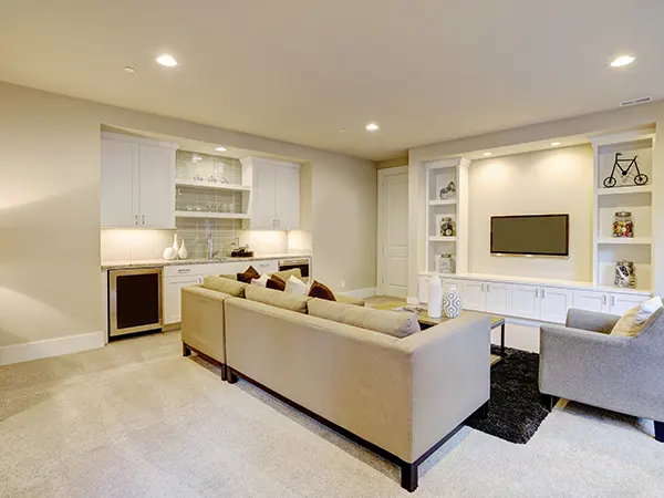 A white basement addition with lights and white couch