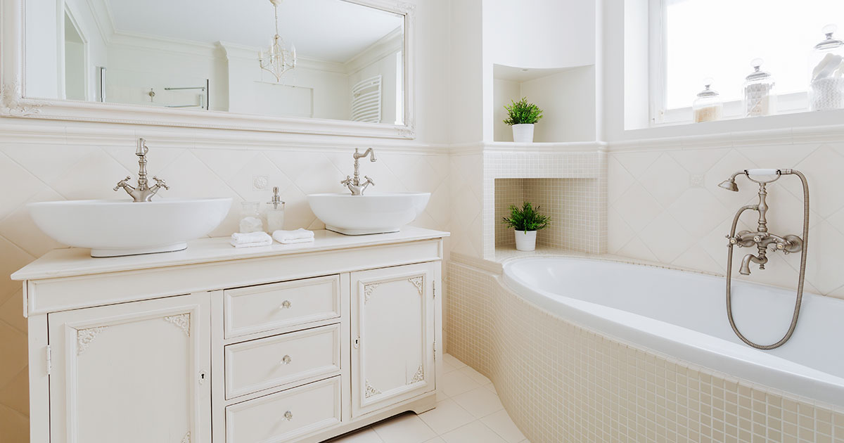 A white bathroom with a decorative vanity and tile flooring and bathtub