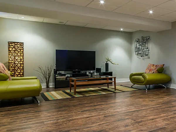 A home theatre in a basement with green couch and big space