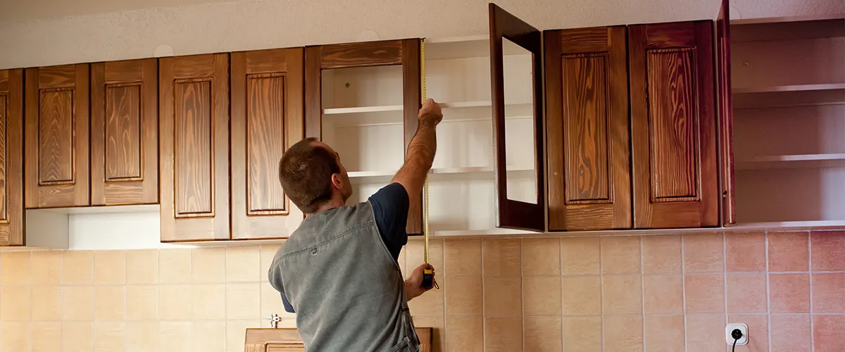 A man installing cabinets hardware