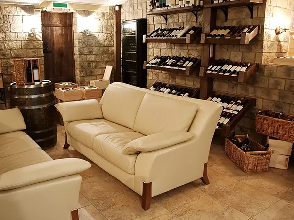 A basement with a private wine cellar and a white couch