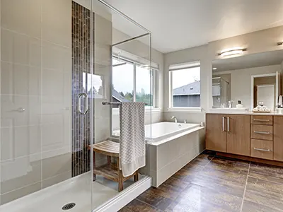 A bathroom with a glass shower and a tub