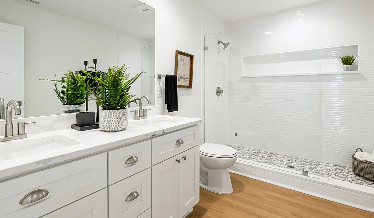 A simple cabinet with silver hardware in a bathroom with wood flooring