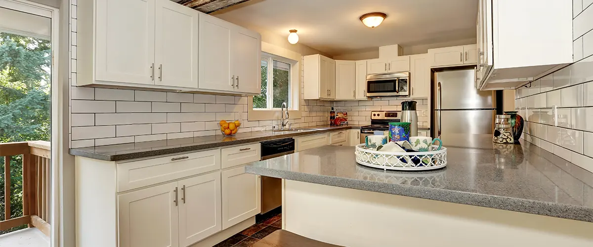 A kitchen with white cabinets and quartz countertops