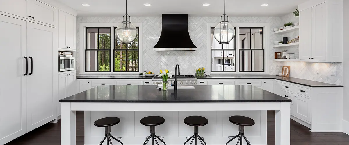 A white kitchen with black stools and counters made in kitchen design apps