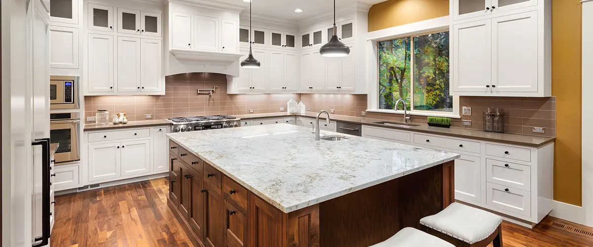 A white countertop on a wood island and white cabinets
