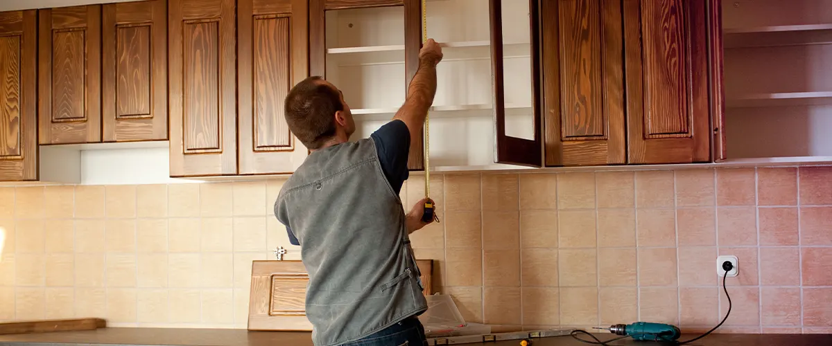 Man refinishing cabinets to prepare for a kitchen remol