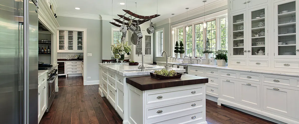 A kitchen with transitional white cabinets and black countertops