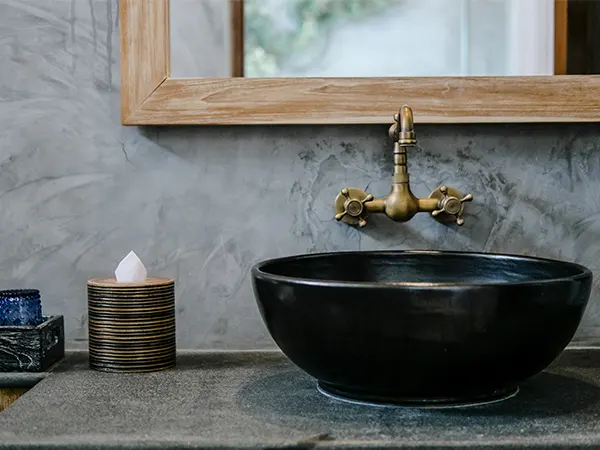 A black sink with a golden faucet