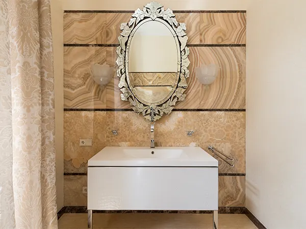 A wall-mounted sink with a round decorative mirror, bathroom remodeling for Overland Park