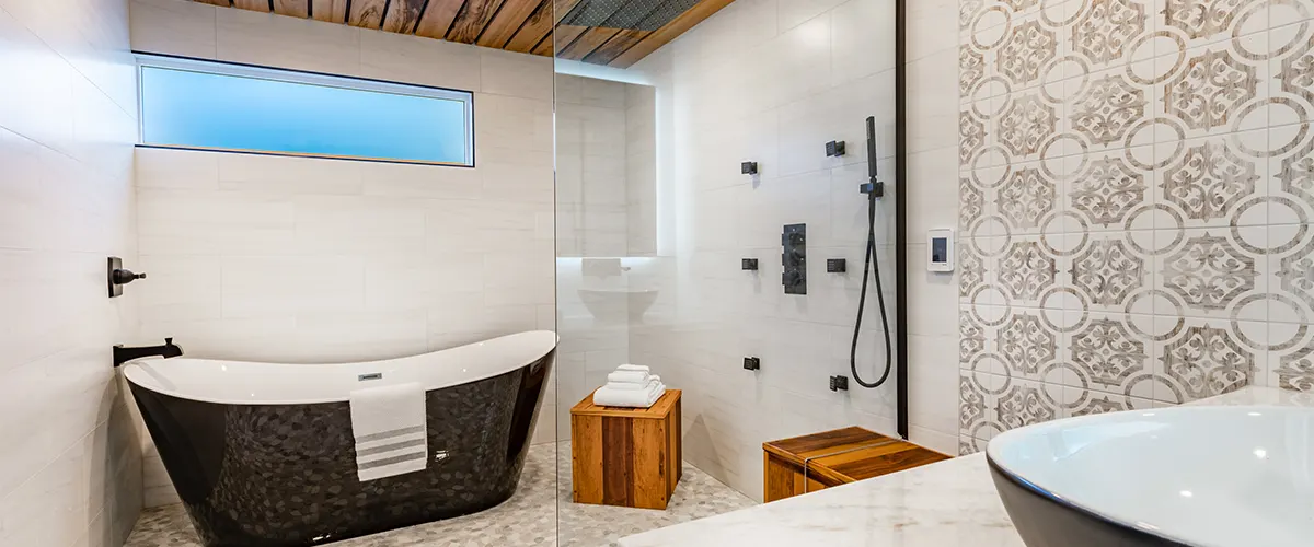 A black tub with wood furniture in a glass shower