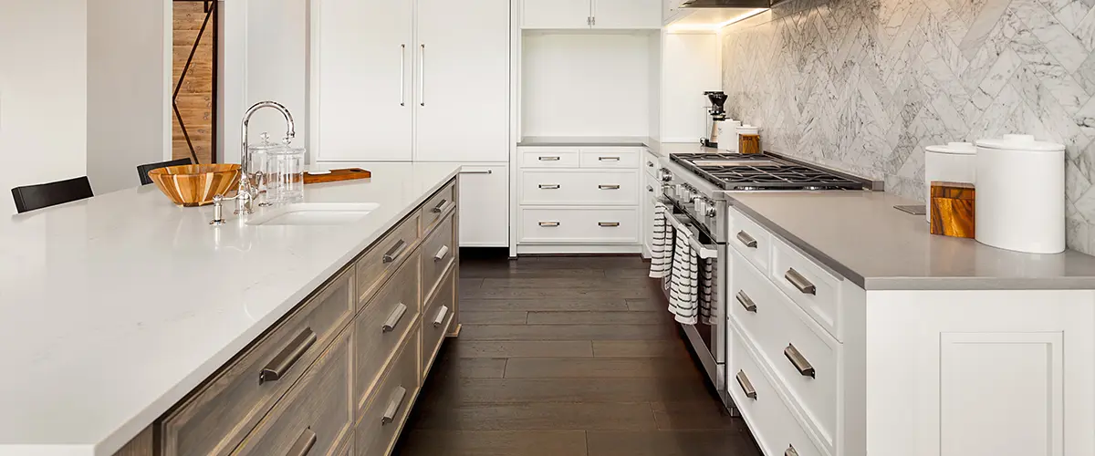 A kitchen with wood flooring and white kitchen cabinets