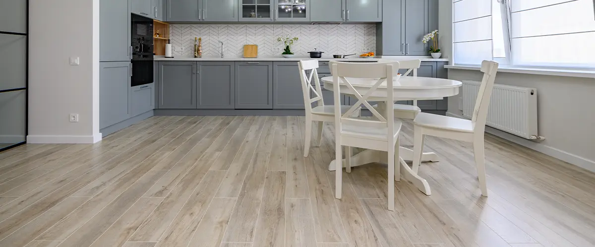 A laminate floor in a kitchen with gray cabinets