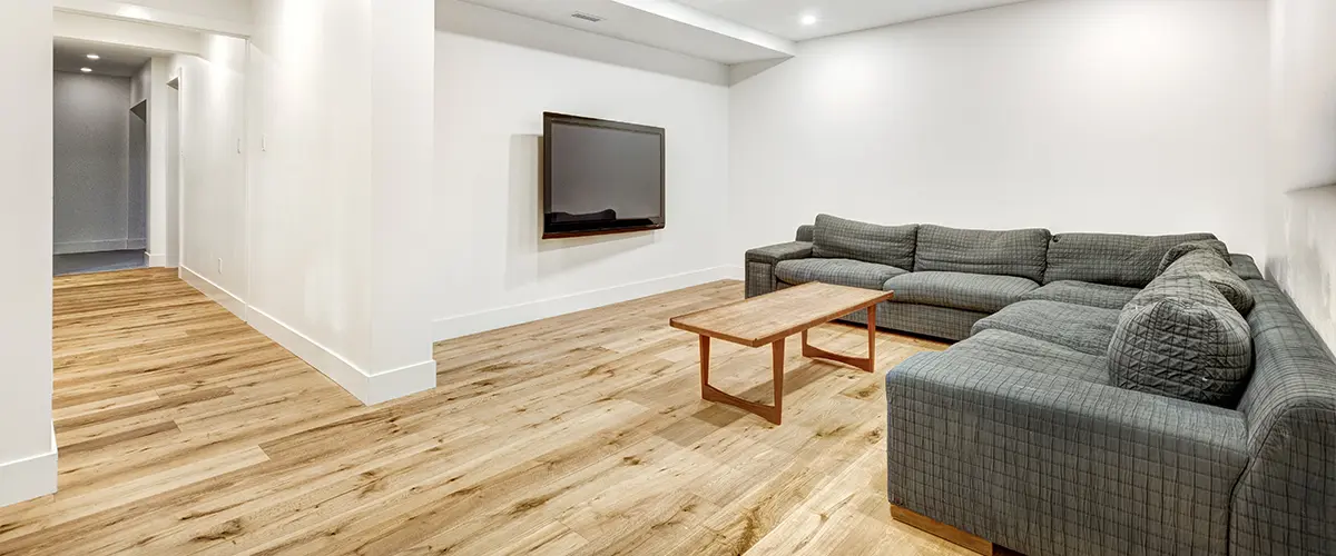 Wood floor in a basement with a large couch