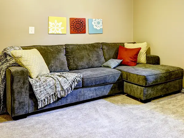 A black couch with pillows in a basement