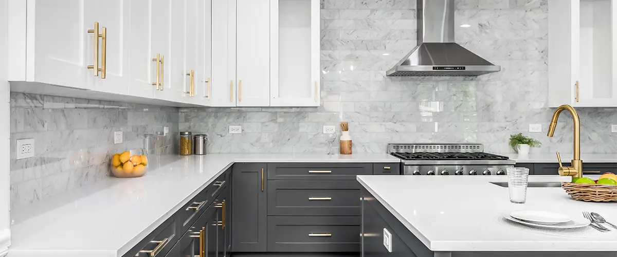 Gray and white kitchen cabinets with golden pulls