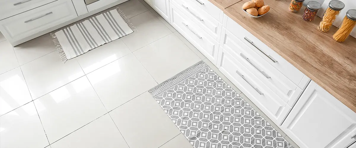 A kitchen tile floor and carpet on it