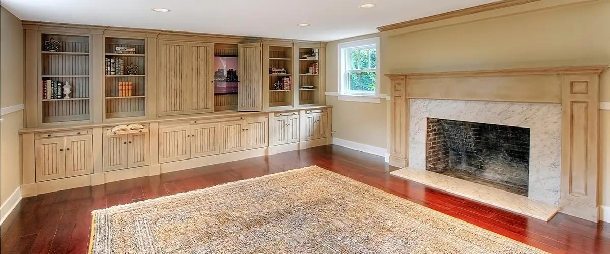 A basement remodeling project with white cabinets and a fireplace
