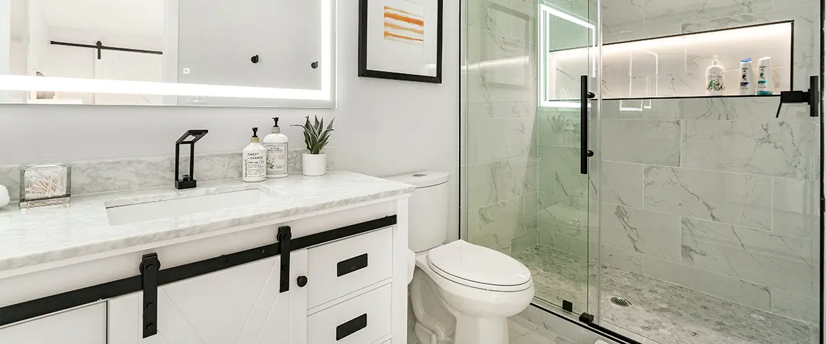 A white vanity with a sliding door and glass walk-in shower